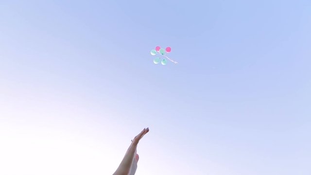 girl let go of balloons on sky background