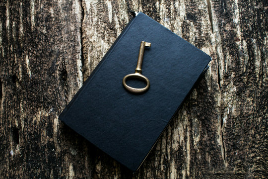 old key and book on wooden background