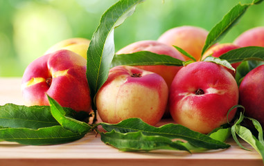 fresh peaches and leaves on table