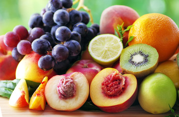 Fototapeta na wymiar Slices of peach, grapes, kiwi and citrus fruits