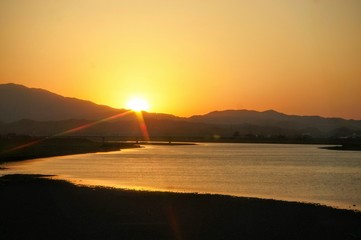 Fototapeta na wymiar 川と夕焼けの車窓