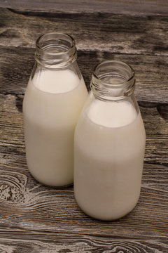 Two bottles of milk on wooden table
