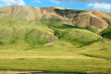 Meadows with green grass on the background of mountain range und