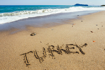 The word Turkey written in the sand on beach