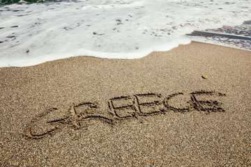 The word Greece written in the sand on beach
