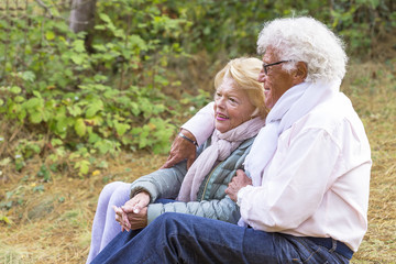  Smiling senior woman and man with arms around at the park