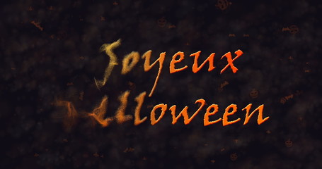 Joyeux Halloween text in French dissolving into dust to left.