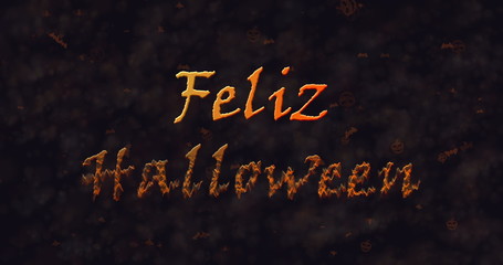 Feliz Halloween text in Spanish dissolving into dust to bottom.