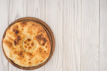 Uzbek bread on old white wooden table.