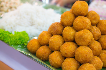 Spicy salad of curried rice croquettes with fermented pork