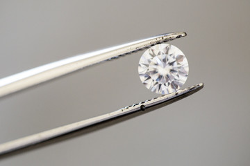 loose brilliant diamond with tweezers 