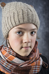 girl in knitwear cap and checkered scarf