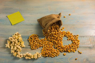 Dried corn and popcorn on a wooden table.Eating popcorn in a relaxing day and love and relationship.