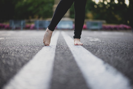 Walking along white zebra line, barefoot.