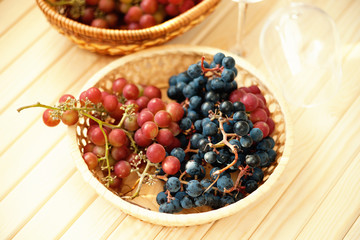 Grape in the wicker basket and empty wine glasses 