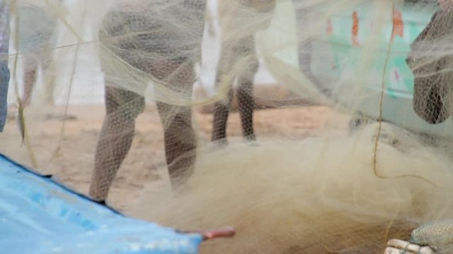 Indian fishermen untangle fishing nets on the beaches of Muttom, India.