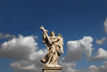 Obraz premium Angel holding Holy Cross with beautiful clouds and copy space