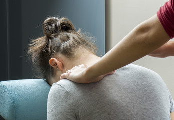 Chiropractor is doing a  office massage on chair