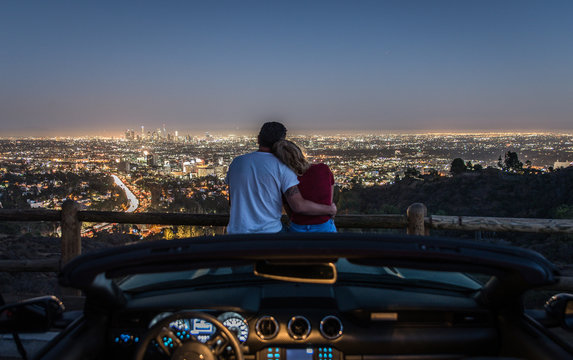 Couple enjoying skyline view from their car