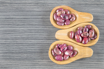 Pinto beans on wooden spoon. (Phaseolus vulgaris)