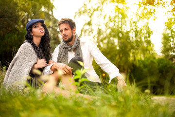 Young couple sitting on the grass in the park