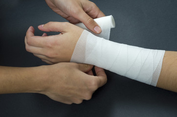 Close-up of woman doctor bandaging a hand