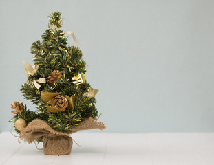 Christmas tree in the sacking on a wooden table.
