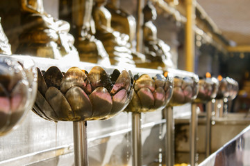 Oil filling in Thai style metal candle in Thai temple, Chiang Ma