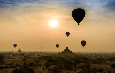 Hot air balloon over misty morning around Temple in Bagan , Myan