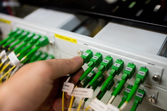 Technician Plugging Patch Cable In A Rack Mounted Server