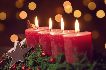 Four Christmascandles are burning under Bokeh