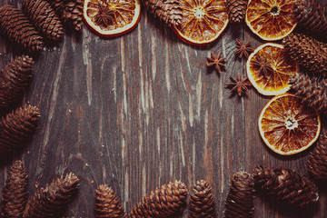 dark wood background with cones,star anise and dry orange  with