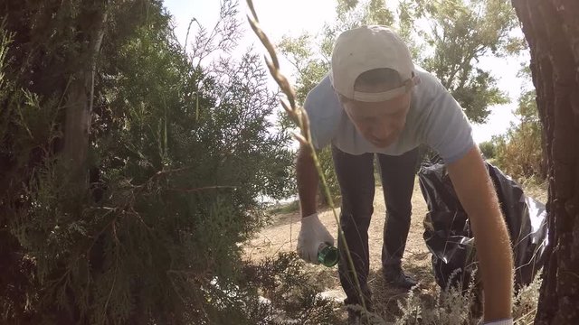 Volunteer removes debris in the forest, slow motion