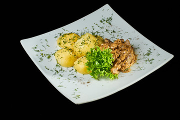 Meat and potatoes on a large white plate. Delicious and nourishing food.