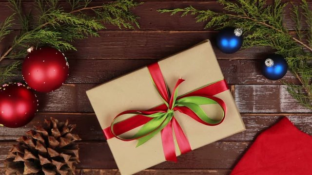 Top view hands holding christmas presents at wooden desk from above