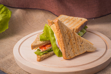 fresh sandwich on a wooden board with texture