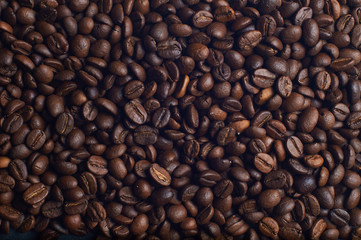 Dark brown coffee beans on the table. Background from coffee beans.