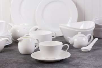 Set of white dishes on grey background