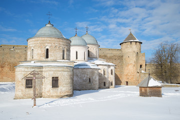 Fototapeta na wymiar Ancient Orthodox churches and Ivangorod fortress Gate tower, sunny March day. Ivangorod, Russia