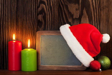 Obraz na płótnie Canvas Christmas chalkboard, candles and santa hat