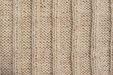 Texture of beige knitted wool sweater with ornament