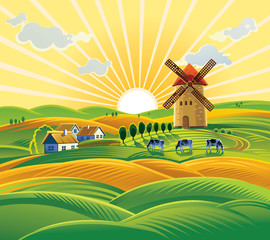 Rural landscape with a windmill, village and herd cows on the background of sunset.