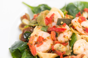 close up on fresh salad of prawns, baby spinach and chili,  on white