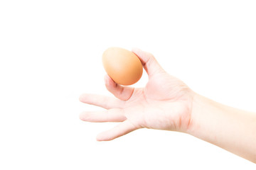 Hand holds a brown egg on a white background