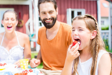 Familie beim Kaffeetrinken - Mädchen isst Erdbeer Kuchen