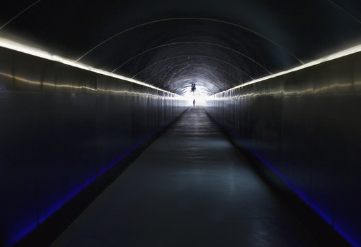 A Person Stands At The End Of A Dark Corridor With Light At The End; Alicante, Spain