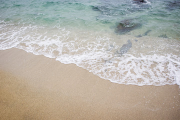 Sand and wave at the beach background. Drop space on bottom right for text and other.