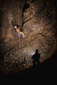 Male Athlete Ascending A Rope To Exit A Cave; Fernie, British Columbia, Canada