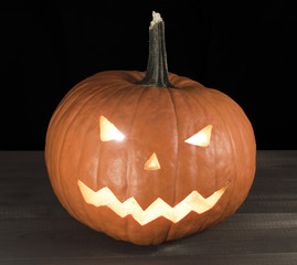 Halloween carved pumpkin, jack-o-lantern on wooden table