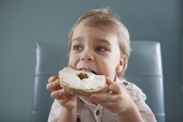 Toddler Biting A Bagel With Cream Cheese; Jordan, Ontario, Canada